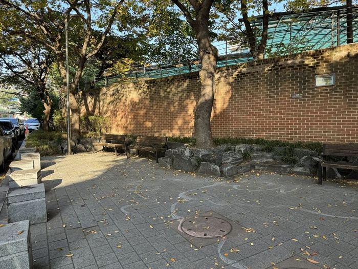 A shaded meeting place beside a brick wall